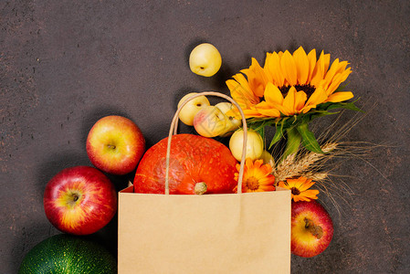 用鲜花装饰的新鲜秋季水果和蔬菜的工艺纸袋秋季销售有机市场丰收节或感恩节的概念形象明亮的顶视图组图片