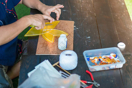 当地市场销售的年长妇女制作和建造恒星形风筝或泰名C背景图片