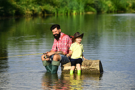 钓鱼成为一种流行的娱乐活动父亲和儿子一起钓鱼垂钓者退图片