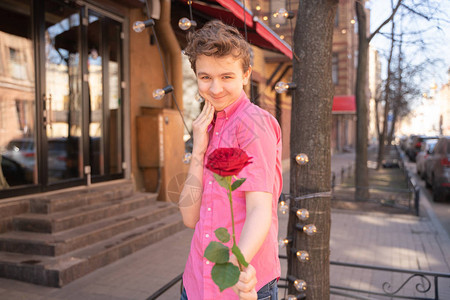 穿粉红衬衫的少年青在市街上穿着图片