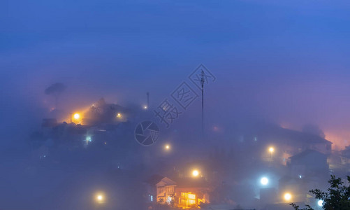 这座城市在夜雾中沉没在烟雾中闪亮的电灯在越南大莱特制造出一幅幻想和令人印图片