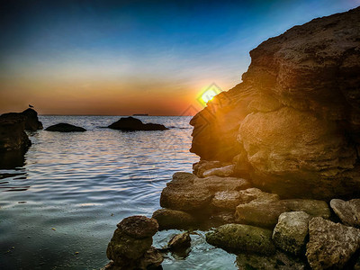 夏季日落时带石头的海线背景图片