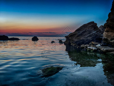 夏季日落时带石头的海线背景图片