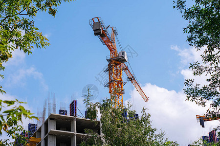 建筑起重机在蓝天和未完工的建筑物上工作与起重机安图片