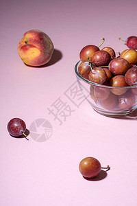 在玻璃碗里放着甜李子水果背景图片