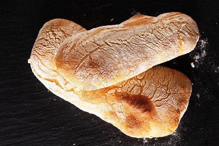 食品概念自制工匠经典意大利式酵母面团Ciabatta面包在黑石板上图片