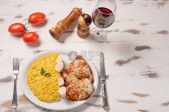 番红花烩饭配帕尔马牛排肉意大利调味饭和牛肉在木制的白色背景图片