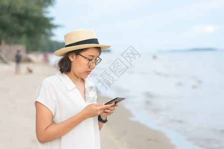 美丽的年轻女子拿着智能手机图片