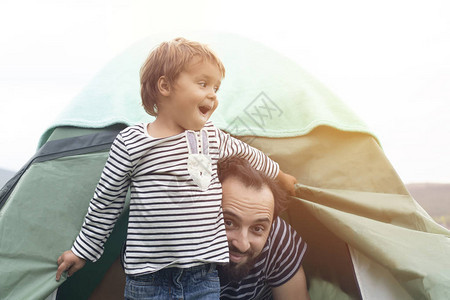 父亲节快乐的家庭度假露营在帐篷里快乐的父子一起在大自然中旅行图片