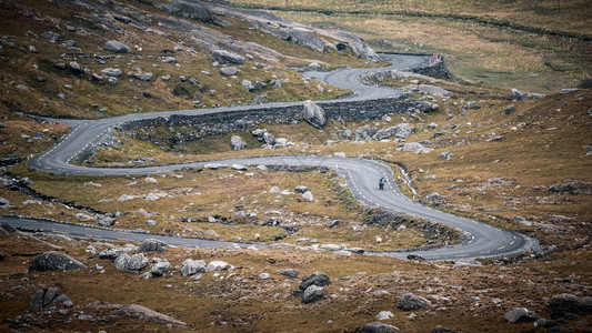 的摩托车手在穿越爱尔兰科克县Beara半岛山谷时顺风下降希利山口图片