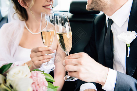 新娘和新郎用香槟杯碰的剪影背景图片