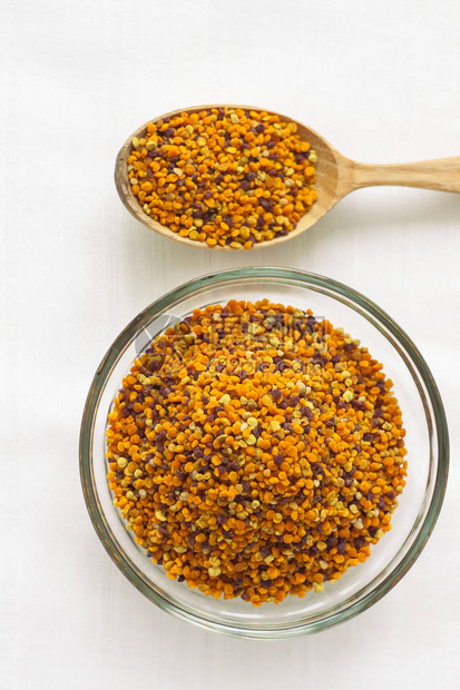 蜂花粉颗粒在玻璃碗和白色背景上的木勺超级食品花蜜酶蜂蜜和蜡营养素氨基酸脂质和维生素Flatlay图片