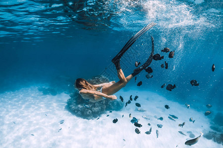 女子自由潜水滑翔在沙海上空有鳍图片
