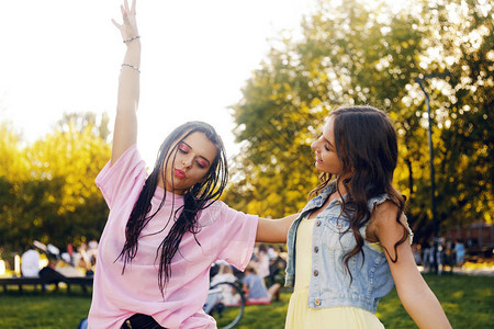 两个黑发女郎在公园里参加节日的画像粉红色舞蹈的两个姐妹朋友女孩摆姿势图片