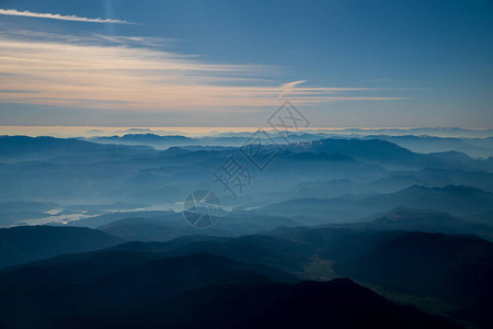 美丽的日出空中山景观云雾覆盖的岩石山峰山链有雪脊的山世界图片