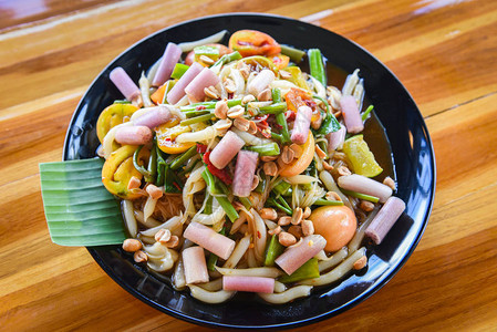 木瓜沙拉上的莲花茎混合面条蔬菜和花生在餐桌上供应米面沙拉泰国辣菜在盘子上图片