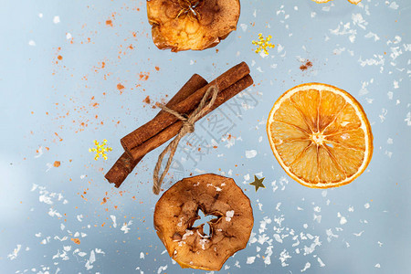Gingercookie配有干苹果和橙子片还有肉桂棒在蓝色背景下飞翔图片