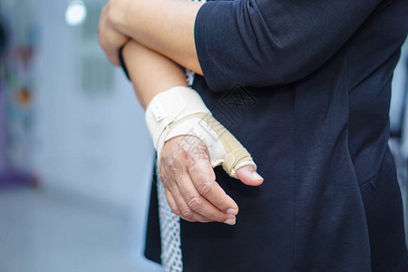 亚洲中年妇女用弹绷带亲手和指在办公室治疗德克韦因综图片