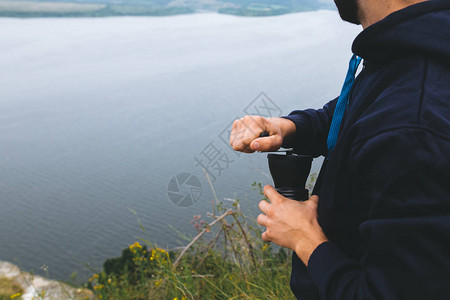 旅行者站在悬崖上一边研磨新鲜的咖啡豆图片