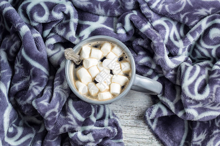 咖啡或可加棉花糖和白色木制桌边的温暖格子圣图片