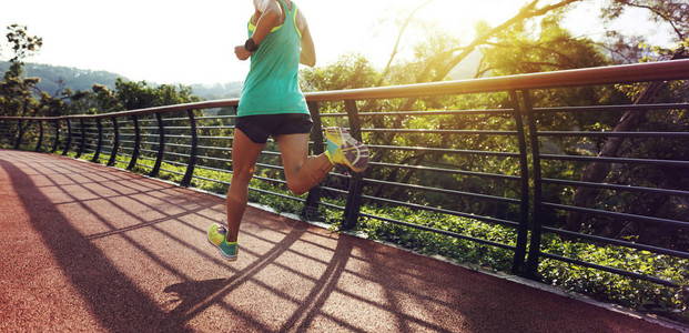 跑步运动员在春季森林足迹上奔跑女健身慢跑锻图片