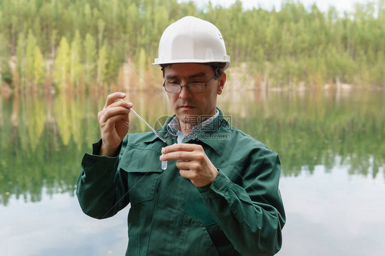 工业生态学家或化学家从洪水采石场的湖图片