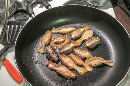 关闭热气腾的野生羊肚菌煎锅的食物照片背景图片