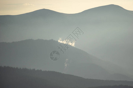 喀尔巴阡山脉傍晚阴霾中的树木繁茂的山丘图片