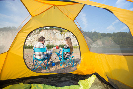 人民旅游与自然概念可爱的情侣坐在黄色帐篷附近图片