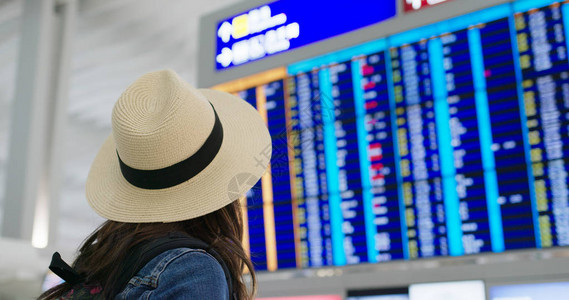 女人在机场看航班时刻表背景图片