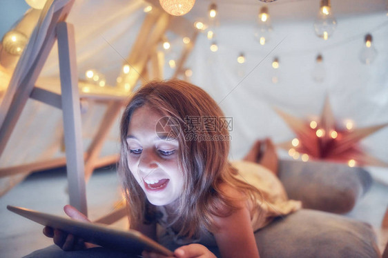 10岁的小女孩在客厅内用平板电脑在她自图片