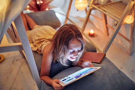 10岁的小女孩在客厅内用平板电脑在她自图片