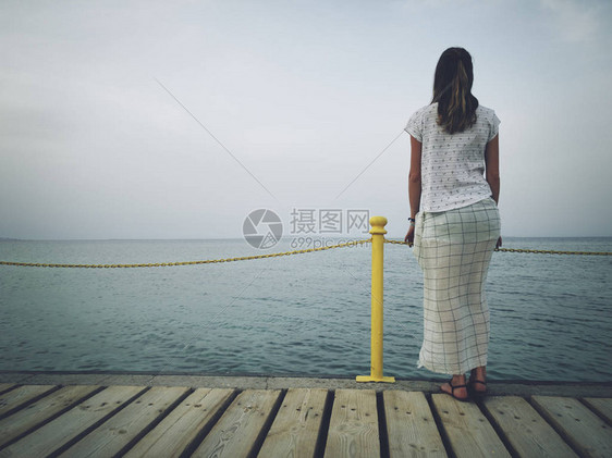 孤独的女人站在大海岸上图片