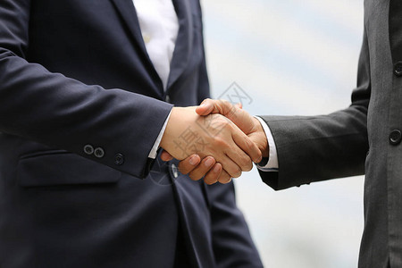 两个商人在户外握手的中段图片
