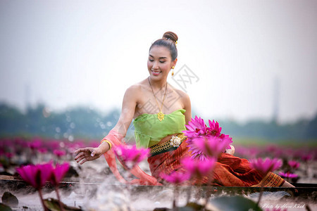 湖中坐船捧莲花的女人图片