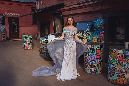 穿着一件有趣的洋装的年轻美女在莫斯科艺术空间红十月上出现为设计师服装目录或时尚杂志拍摄非同寻图片