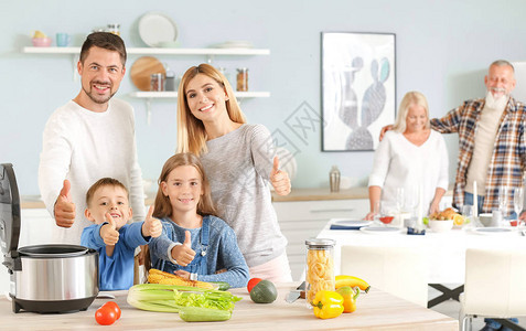 快乐的家庭与现代多厨艺家在厨房露图片