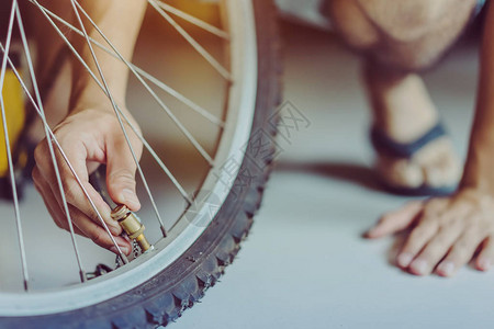 一个年轻人的近身准备把旧自行车轮抽图片