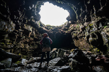 女旅行者在冰岛探索熔岩隧道Raufarholshellir是一个美丽的隐藏洞穴世界它是欧洲冰岛最长最著名的熔岩管之一图片