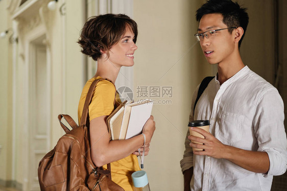 两个年轻漂亮的国际休闲学生在大学走廊图片