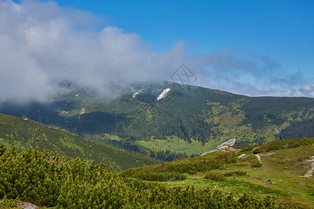 山中的夏日风景和乌云密布的深蓝色天空图片