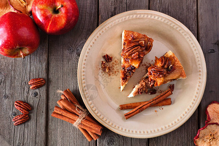 两片焦糖苹果核桃芝士蛋糕生锈木质背景的顶端桌子图片