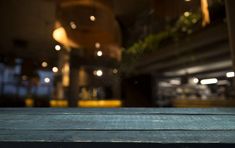 现代厨房深色背景下咖啡馆餐厅模糊浅金色散景上的空木桌面背景