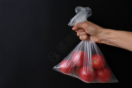伸出手臂的袋子里的西红柿图片