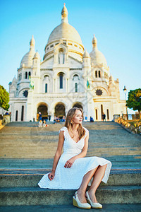 在法国巴黎著名的蒙特马尔山圣心教堂附近穿着白色礼服的漂亮年图片