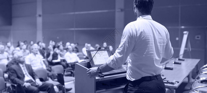 演讲者就企业商务会议发表演讲会议厅的观众商业和创业活动全景组成灰度蓝图片