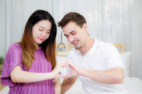 怀孕的母亲和父亲坐着甜美的手心形状图片