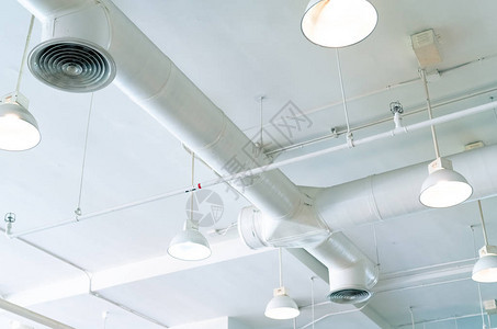 风管空调管接线管消防喷淋系统气流和通风系统建筑内部天花灯带开灯背景图片