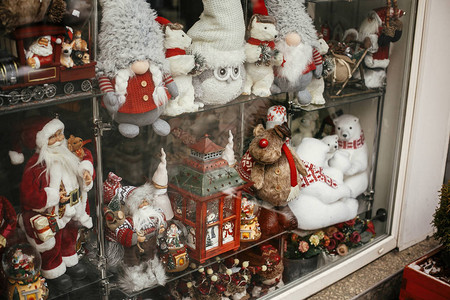 圣诞街头装饰时尚的橱窗商店与圣诞玩具在城市街道的假日市场现代圣诞老人北极熊猫头鹰驯鹿玩具在展示中图片