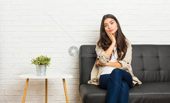 坐在沙发上的年轻阿拉伯妇女她无聊疲劳图片